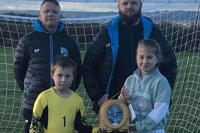Coaches Shaun Pask and Lewis Preece with Brimington Little Stars FC players Lucas and Leah with the defibrillator.