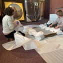 Chesterfield Museum Collection Officers Maria Barnes and Rachel Fannen preparing the portrait of George Albert Eastwood, a former mayor of Chesterfield, for the move