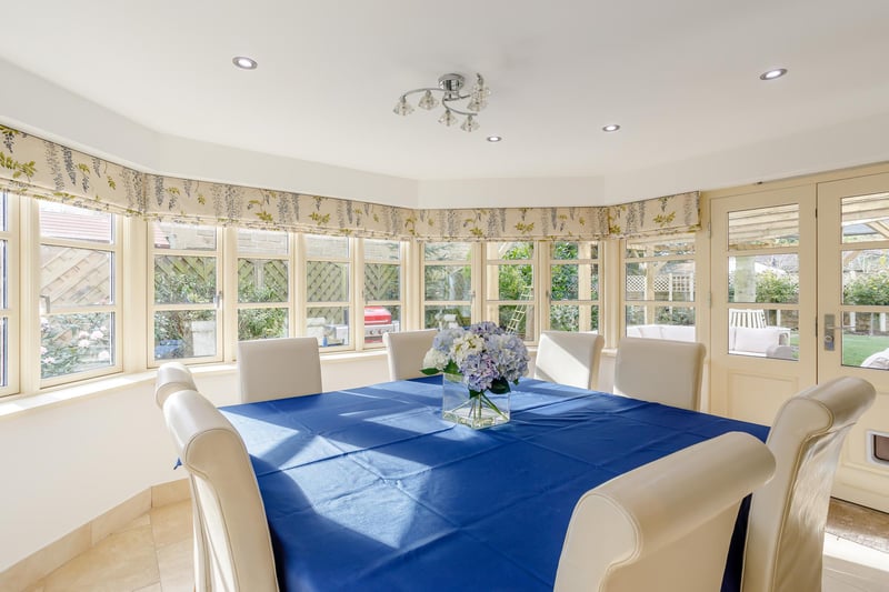 The dining area natural light streaming in through multiple windows and French doors to the rear garden