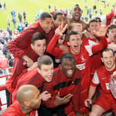 The team celebrate with the trophy after the game.