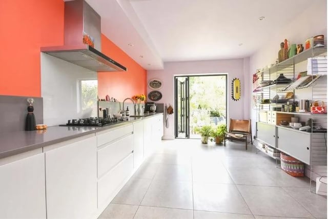 The streamlined kitchen is fitted with modern units and bi-fold doors opening to the enclosed, private rear garden.