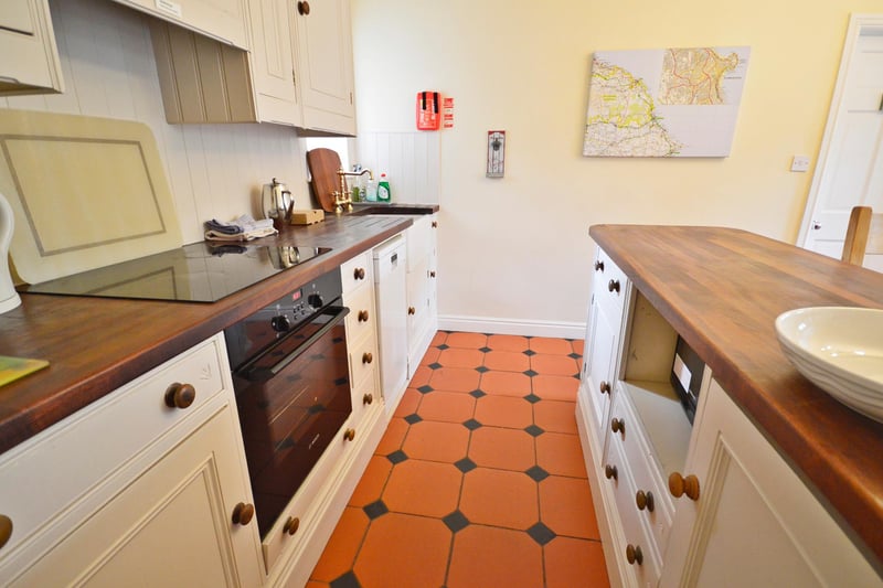The kitchen has a Belfast sink and modern base and wall units.