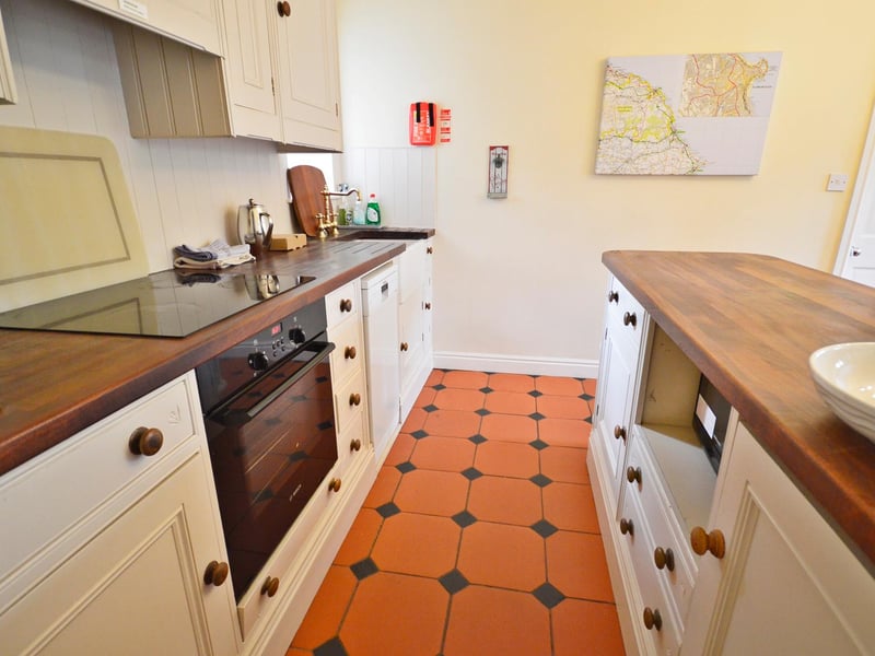 The kitchen has a Belfast sink and modern base and wall units.