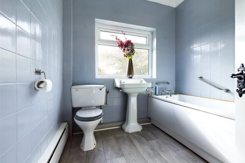 Bathroom with a three piece white suite, window to the rear and access to the loft which is  boarded with folding ladder and lighting
