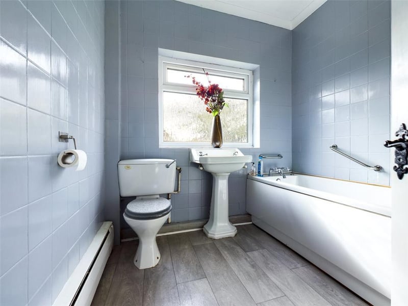 Bathroom with a three piece white suite, window to the rear and access to the loft which is boarded with folding ladder and lighting