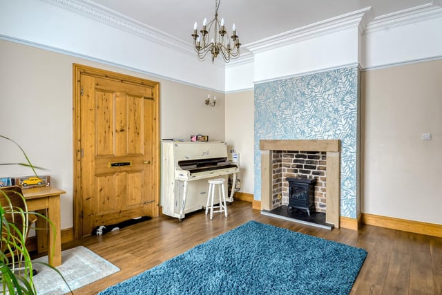 A charming fireplace set within the chimney breast catches the eye in this reception room which is adorned with ceiling coving, picture rails and wood effect flooring.