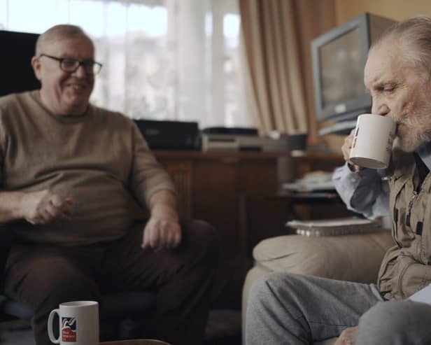 Volunteer Liam (left) with blind veteran Ken enjoying a cup of tea and a chat