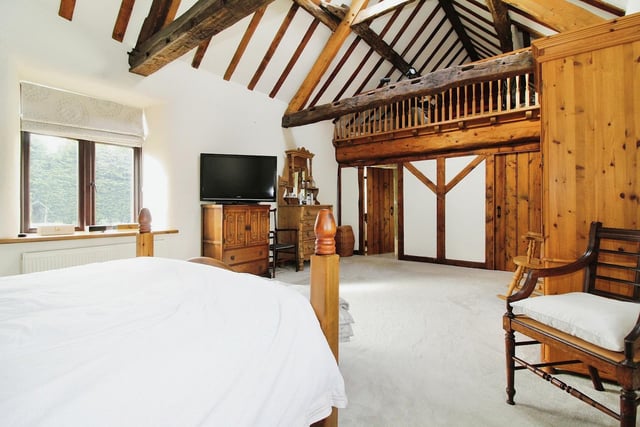 The second bedroom at Frithwood Farmhouse is a spectacular sight, especially with its high-level mezzanine storage area, beamed ceiling and Velux skylight window.