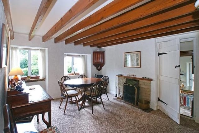 This characterful room has a fireplace with stone surround and a latched door leading to the kitchen.