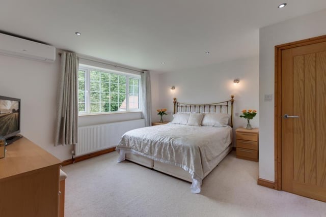 Stay cool on a warm summer's night in this bedroom where there is an air conditioning unit and a window looking out onto the rear of the property.