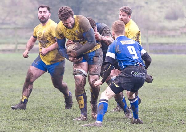 Matlock's George Whittaker battles through the mud at Cromford Meadows against Long Eaton. Photo by Colin Baker.