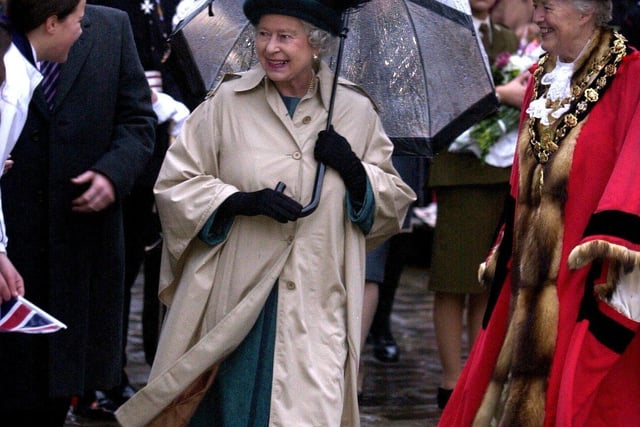 The Queen is seen hanging onto her brolly with two hands in the strong wind during her 'walkabout' in Chesterfield on November 14, 2003. During her visit to the town she opened the town's Magistrate’s Court.