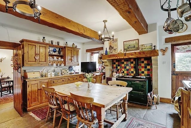 This cosy kitchen with exposed beams, stone flagged floor and wooden storage cabinets oozes rustic charm. The Aga cooker is included in the sale.