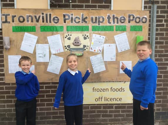 Pupils from Ironville and Codnor Park Primary School with their letters to dog owners on the community board outside the Post Office