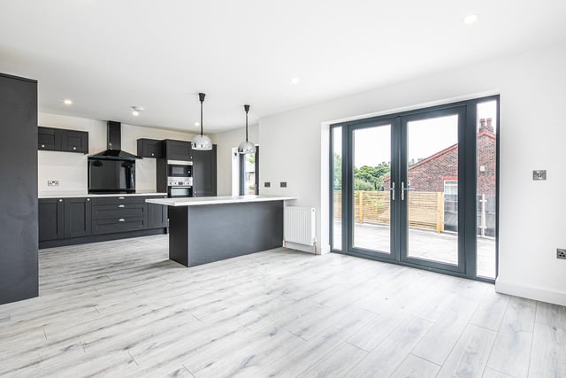 A fully fitted kitchen, pendant lights and doors to the outside terrace are selling points of the open-plan downstairs living space.