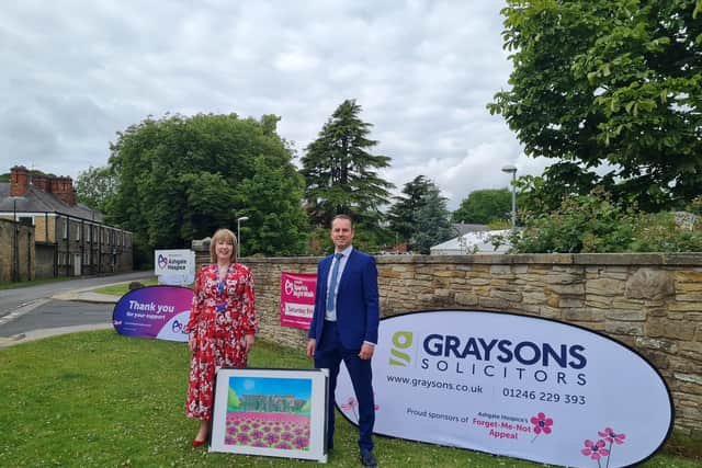 Barbara-Anne Walker, chief executive of Ashgate Hospice, receives the Alan Pennington painting from Chris Shaw, senior private client advisor at Graysons Solicitors.