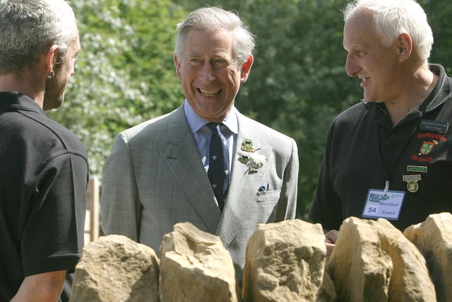 Prince Charles shares a joke with dry stone wallers Adrian Walker and Trevor Wragg during a visit to Edale.
