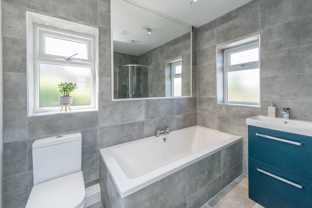 The bathroom is tiled in an elegant shade of light grey.