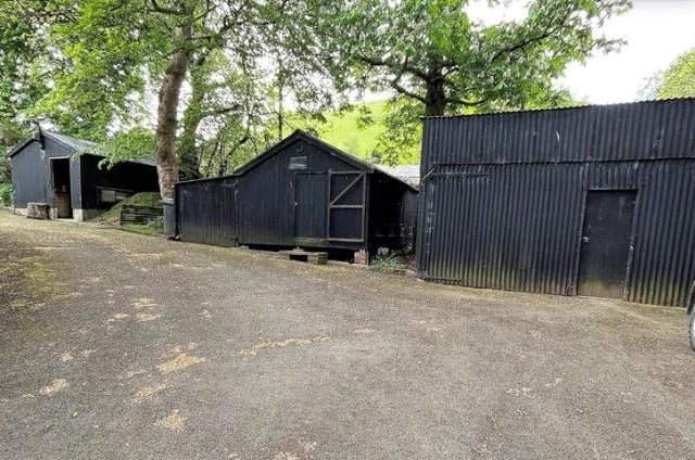 There is a large garage with an inspection pit and additional outbuildings including shed and workshops and a timber summerhouse.