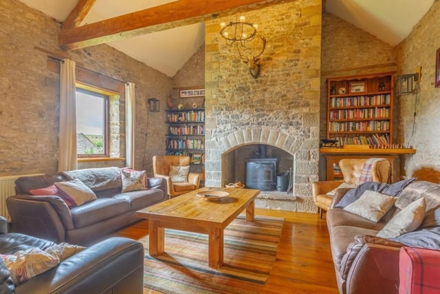 The large lounge has a multi-fuel log burner sitting in an impressive stone fireplace.