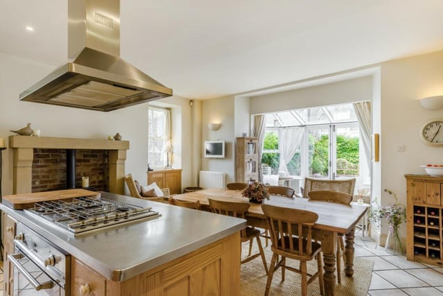 The kitchen has solid wood storage units, double Belfast sink, stainless steel topped island with gas hob and wine store and a spacious pantry. The dining area is naturally lit by an open conservatory.
