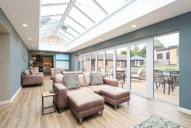 This eye-catching orangery has a lantern roof and bi-fold doors leading out onto the rear garden.