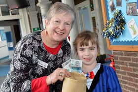 Esther Walker, seven, hands money she raised to Yvonne Birchmore from Loundsley Green Foodbank.