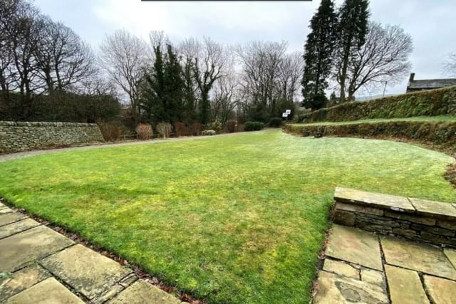 The garden has a well-manicured lawn and large seating area.