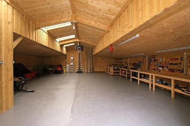 Timber clad portal frame and breezeblock barn/workshop is insulated timber lined and has a sealed floor. The building has fitted work and mobile benches, storage shelving, power, light and an alarm system.