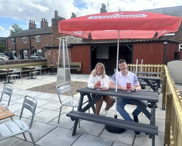 The Bridge Inn's tenants Sophie and Dan Orton relax in their pub's outdoor space which now boasts a new bar, patio and picket fencing.