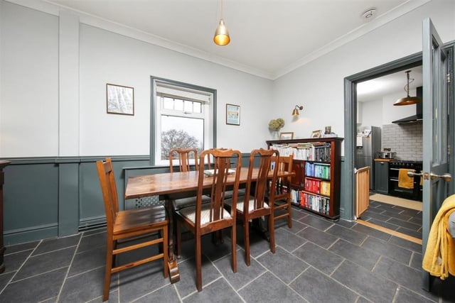 The dining area with a door leading to the kitchen is at one end of the open-plan living room