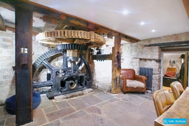 Original mill workings of a cast iron wheel and wooden drive wheels are at one end of the dining kitchen.