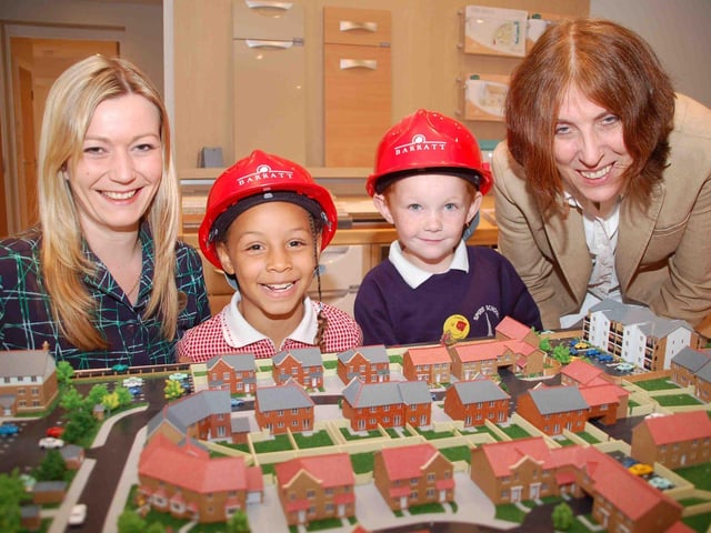 Talia Knight and Frankie Wigley, both 6, get a bird's eye view of the model of Barratt's The Spires development in Chesterfield with sales negotiator Caroline Hale and teacher Jane Garrett in 2006