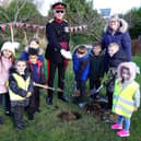 Her Majestys Vice Lord Lieutenant Col. John Wilson OBE and Spire Infant and Nursery School headteacher Kelly Hill plant the Queens Green Canopy tree with help from some children.