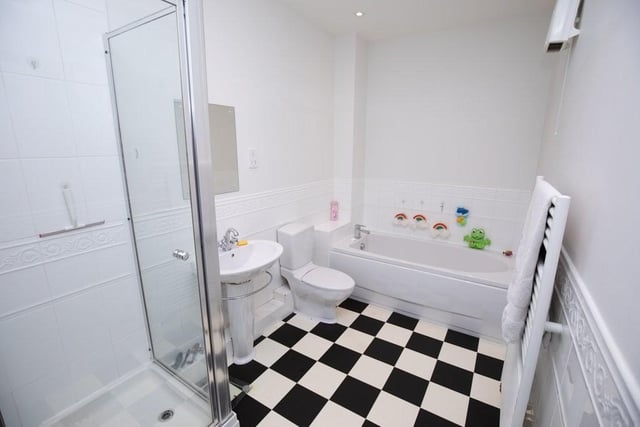 This partially tiled room has a cubicle containing mixer shower and handheld shower spray, wash basin and wc.