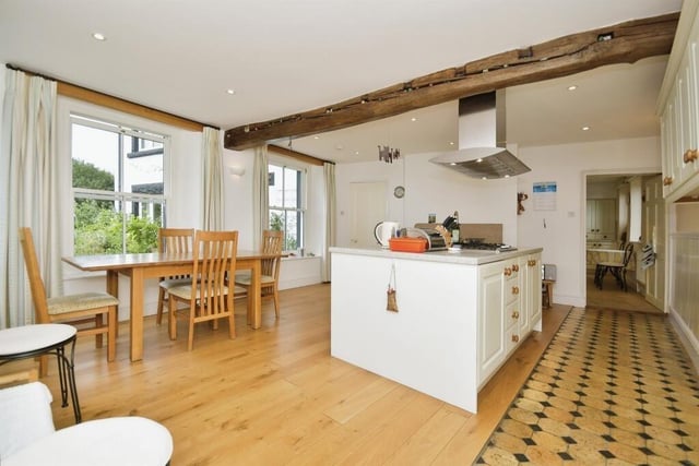 The spacious kitchen is divided into two areas. The main dining kitchen has a large island incorporating a gas hob with extractor over and a circular sink.  Eye-catching features in this room include a log burner and exposed ceiling beam.