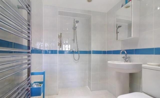 A walk-in shower enclosure, wash basin and wc are contained within the wet room.