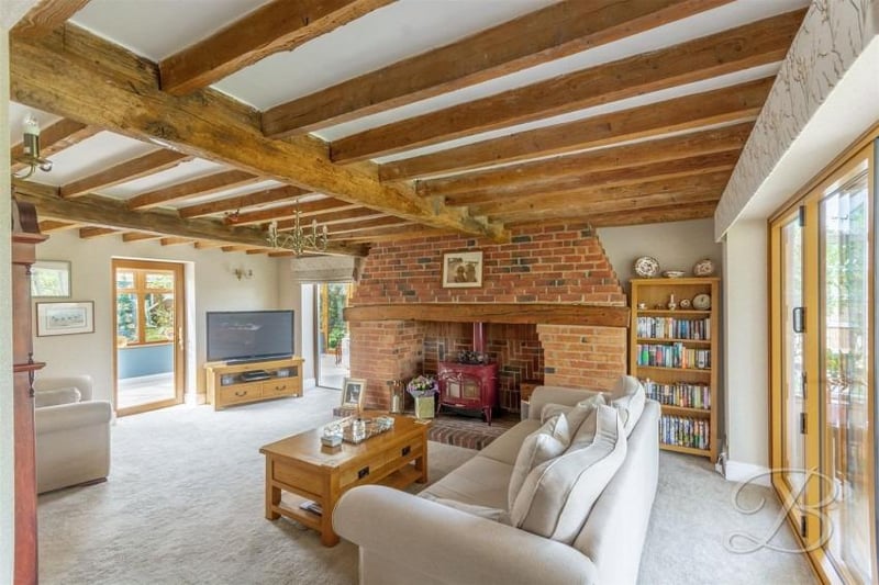 We start our tour of the Kirkby barn conversion in the delightful lounge, where retained original features include striking, exposed ceiling beams. The floor is carpeted and doors open into both of the property's conservatories.