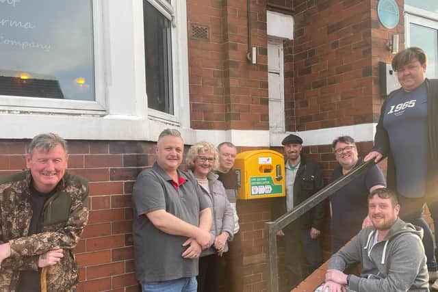Billy, Vena and some of the other fantastic fundraisers and contributors stood beside the the latest defibrillator station.