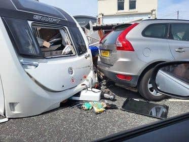 Witnesses say the caravan has 'just about disintegrated' following the collision this afternoon