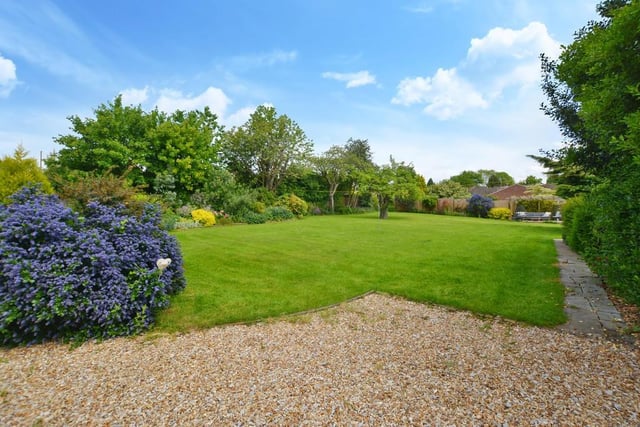 Gorgeous greenery, flowers, shrubs, vegetable beds and fruit beds add to the appeal of the extensive garden on the near half-acre plot of land.