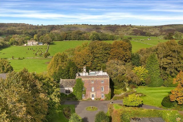 The stunning country house is set in formal gardens with views of the Peak District beyond.