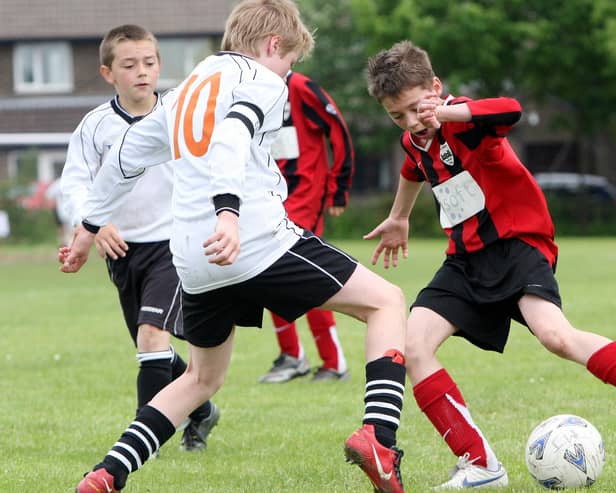 Action from the under 12s final between Wingerworth Villa Whites( white and black) and Matlock Tornadoes(red and black)at the Matlock Juniors Football tournament, Cavendish Fields.