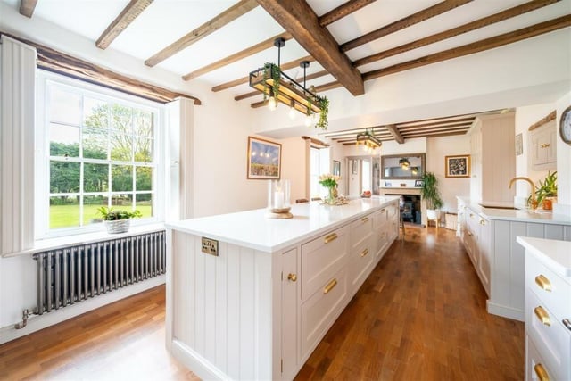 The stunning kitchen has been handmade and handpainted and has integrated appliances. There is a log burning stove at one end of the room.