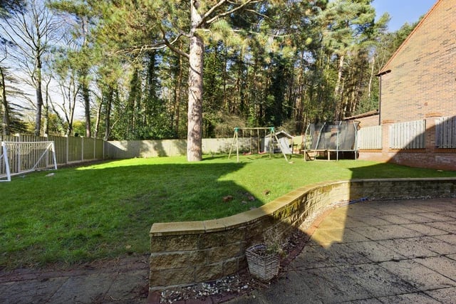 A patio and lawn are features of the rear garden that backs onto woodlands.