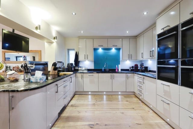 The sparkling kitchen boasts top-of-the-range appliances, such as a rising extractor fan, two hide-and-slide ovens, a combi-microwave, a steamer, under-counter fridge, double fridge freezer, wine fridge, induction hob and waste disposal system.