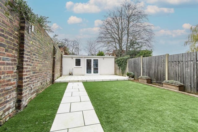 The low maintenance rear garden has at artificial lawn leading to a paved patio and large outbuilding.