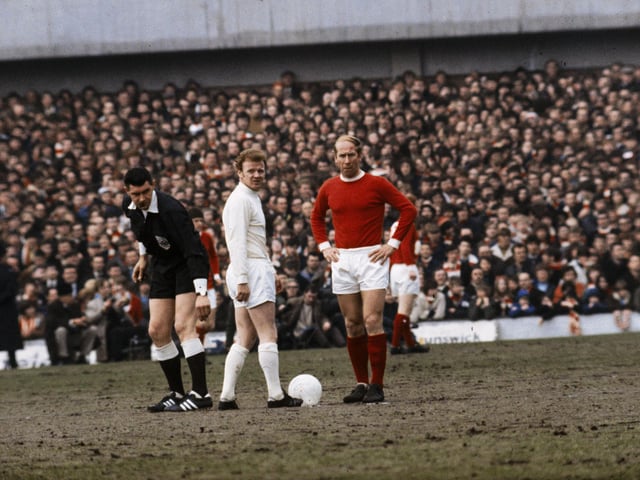 1970: Billy Bremner and Bobby Charlton of Manchester United with referee Jack Taylor during a match.