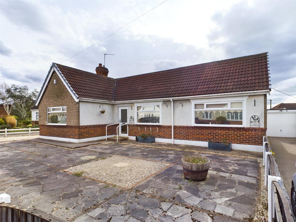 Paved front garden with boundary fence and driveway providin of road parking  and access to the garage