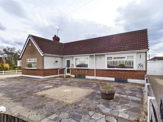 Paved front garden with boundary fence and driveway providin of road parking and access to the garage
